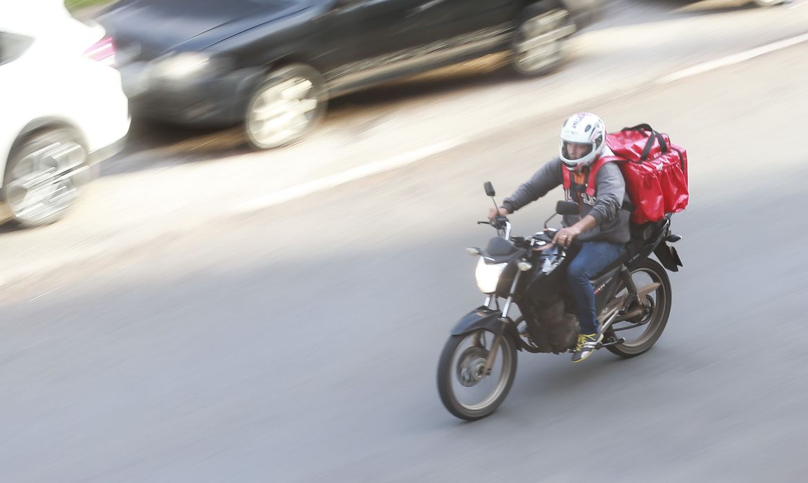 Imagem mostra entregador de moto em alta velocidade