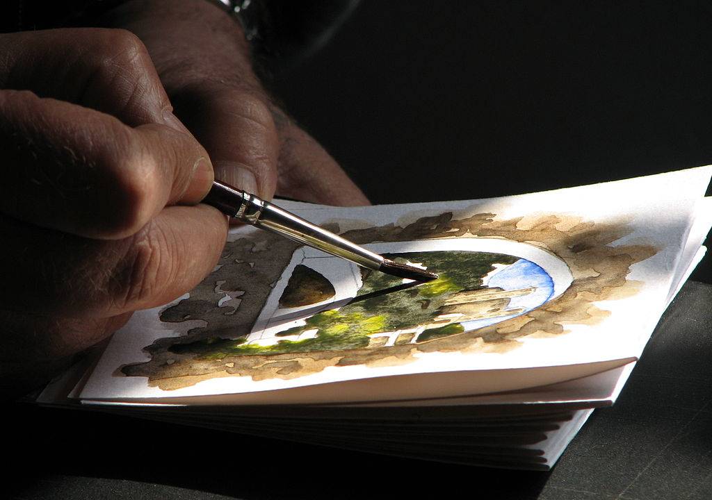 Pessoa pintando uma papel com a técnica da aquarela