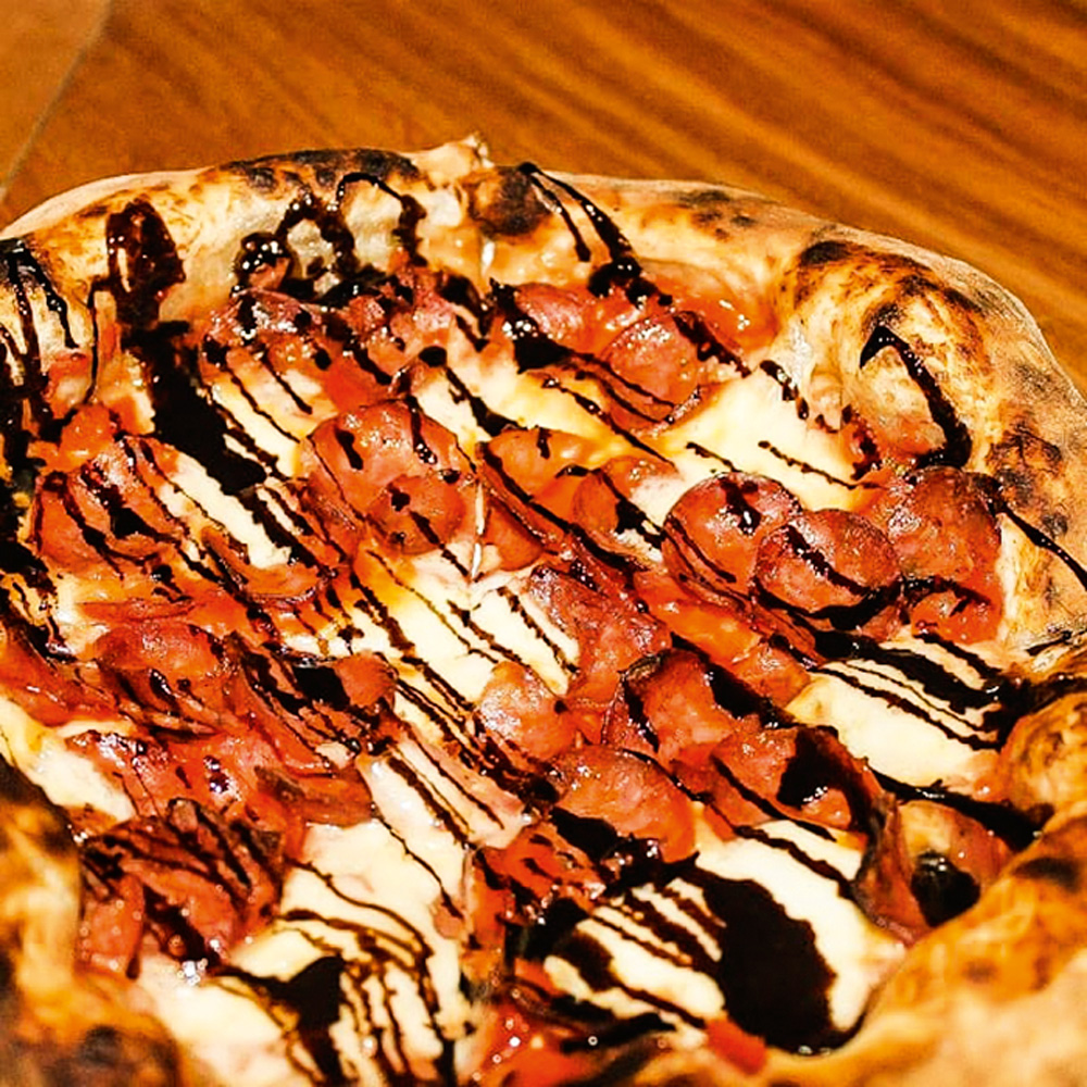 Pizza coberta de muçarela e salame picante, regada com redução de vinagre balsâmico