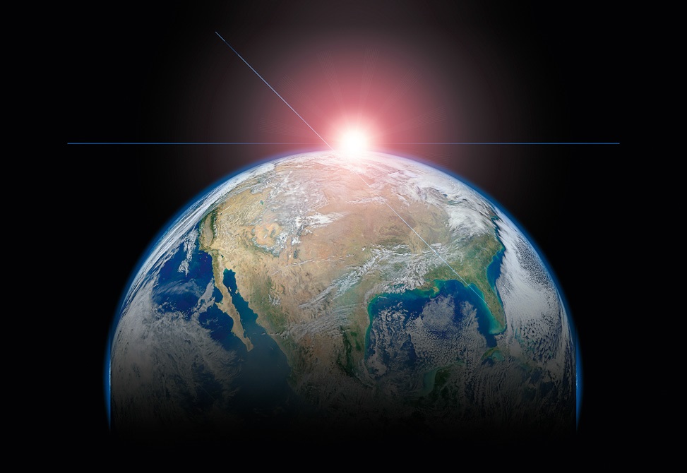 Foto do mundo tirada do espaço, com metade do globo sobreposta com uma sombra preta e uma luz no fundo da imagem