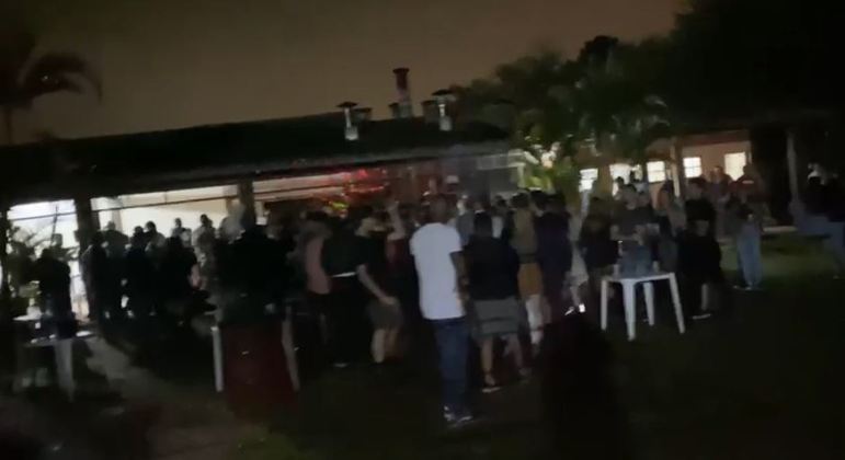 Imagem retirada de vídeo revela aglomeração de pessoas à noite em festa clandestina.