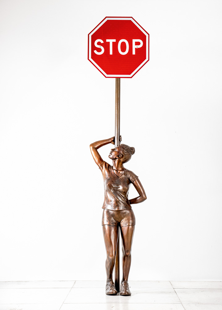 Escultura de Flávio Cerqueira em bronze com uma menina com uma placa STOP (de trânsito) na cabeça