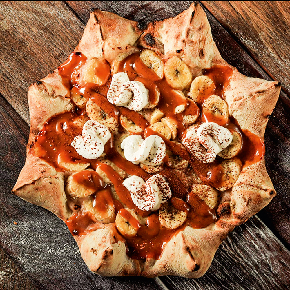 Pizza no formato de estrela, com cobertura de doce de leite, chantili e banana