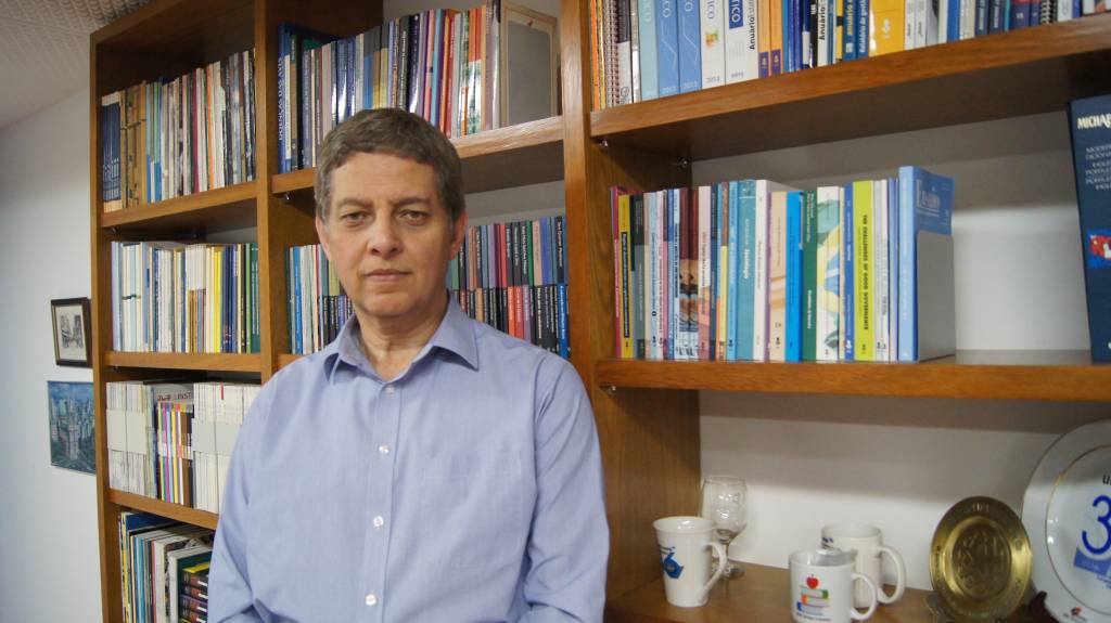 Jézio Gutierre, diretor-presidente da Fundação Editora da Unesp, posa em frente a estante de livros.