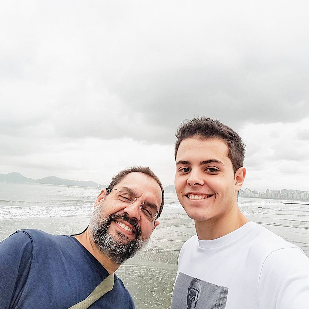 Lucas e o pai.jpg Lucas tira uma selfie com o pai, e na fotografia estão os dois sorrindo com uma praia ao fundo