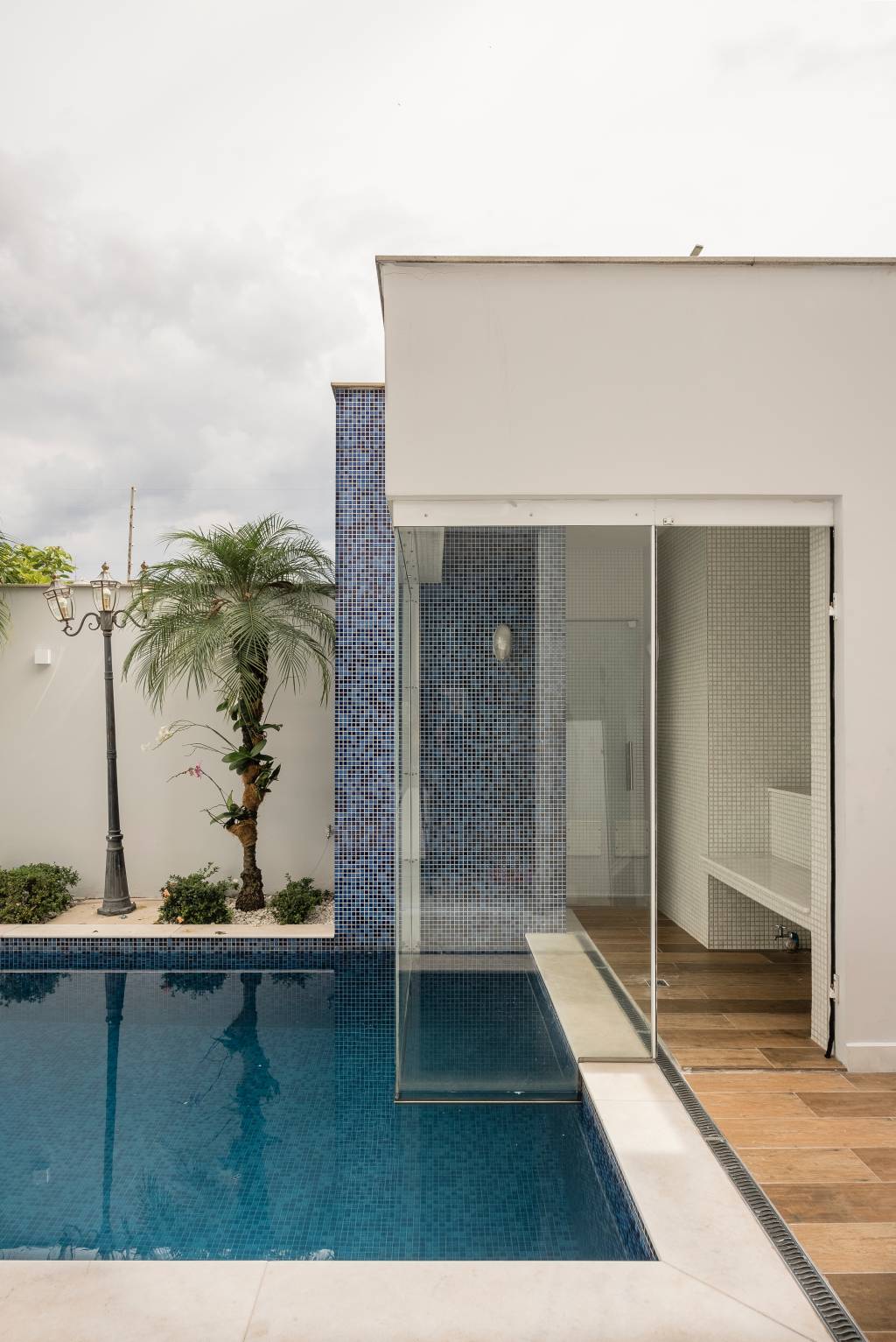 Parte da piscina da casa do músico Marcos, de Marcos & Belutti. Ao fundo, plantas e muro branco aparecem na foto.