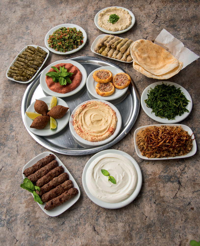 Mesa com pratos como esfirra, quibe e charutinho que fazem parte do rodízio do Monte Líbano