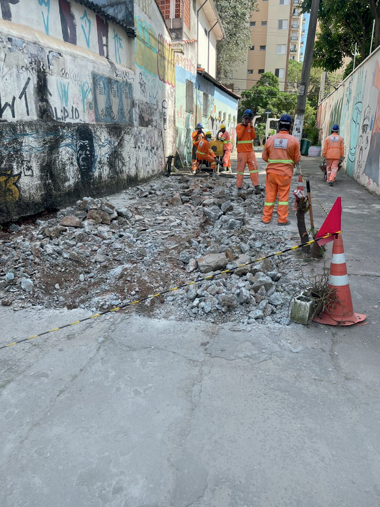 Funcionários da prefeitura reparando asfalto da travessa