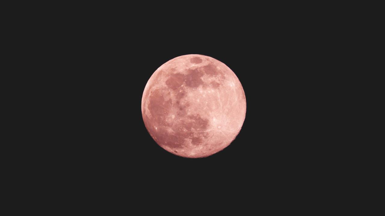 A imagem mostra a lua em tons de rosa