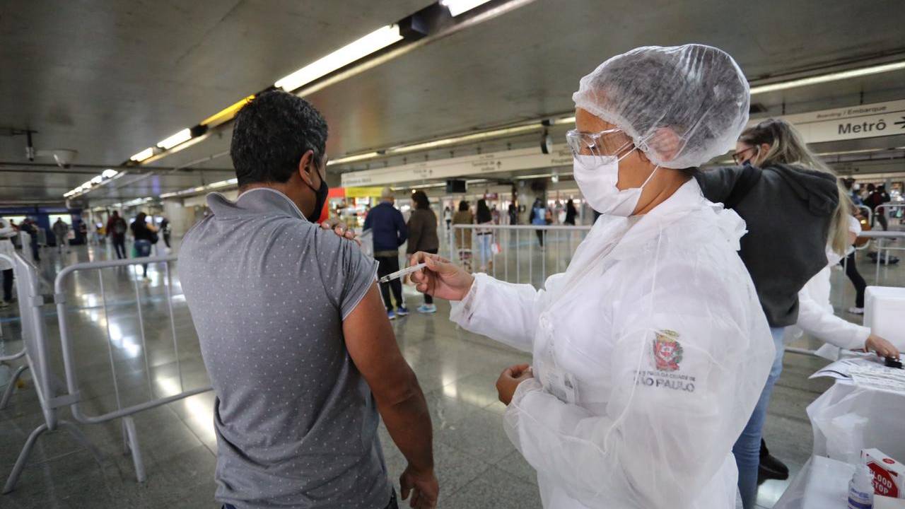 Imagem mostra enfermeira aplicando dose de vacina contra a Covid-19 em estação do Metrô