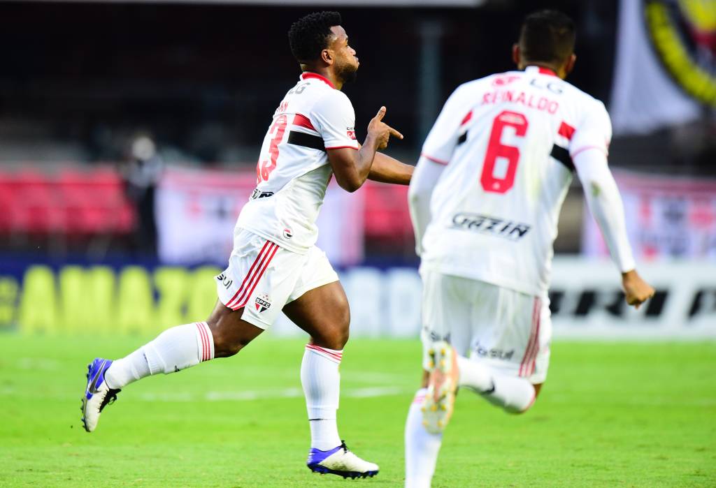 A imagem mostra Luan seguido de Reinaldo comemorando gol no gramado do Morumbi.