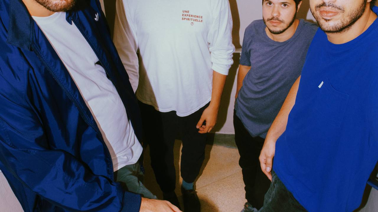 Alinhados em uma pequena escada branca, os fundador do selo de música eletrônica posam de pé olhando para a câmera. Na ordem, aparecem Caio Taborda, Bruno Protti, Fernando Nascii e Gui Scott. Vestem roupas brancas e em tons azuis.