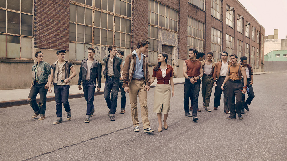 A imagem retrata uma cena do filme de Spielberg em que os personagens estão andando na rua com roupas típicas da época