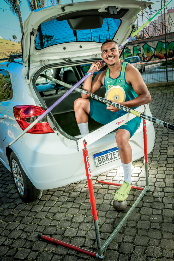 Olimpíadas-Tóquio-Atleta-Jeferson-dos-Santos A imagem mostra Jefferson, com seus equipamentos do decatlon, sentado no porta-malas do carro