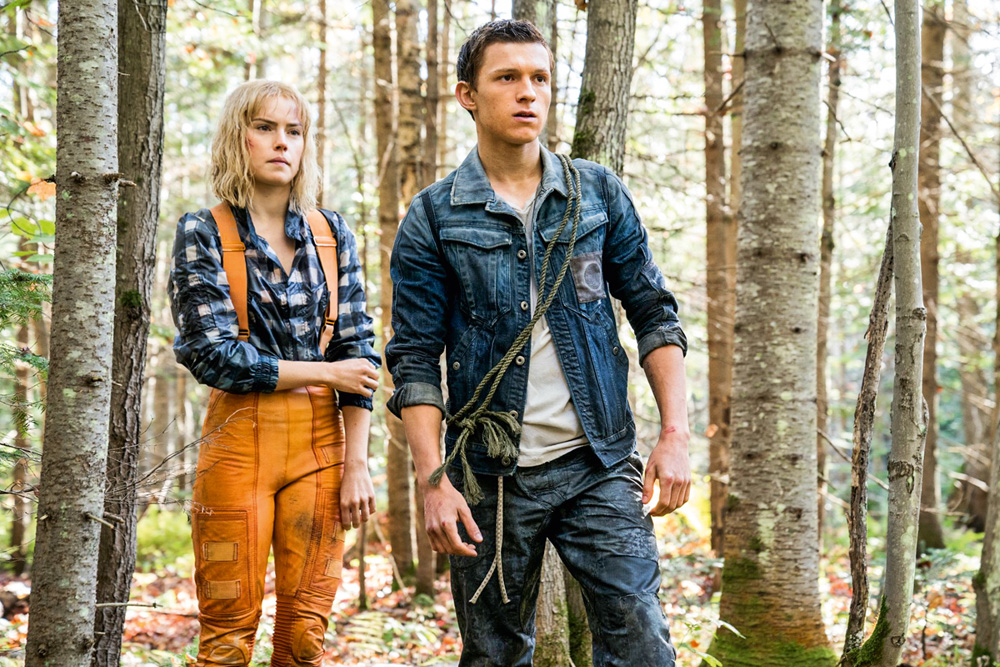 A imagem mostra os atores Ridley e Holland em uma floresta durante o filme.