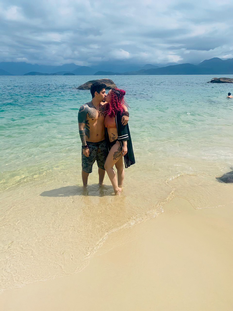 Rodrigo e Juliana na praia, na beira do mar, dando um beijo