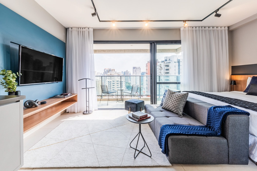 imagem de uma sala de estar de um apartamento, com sofá à direita e televisão à esquerda