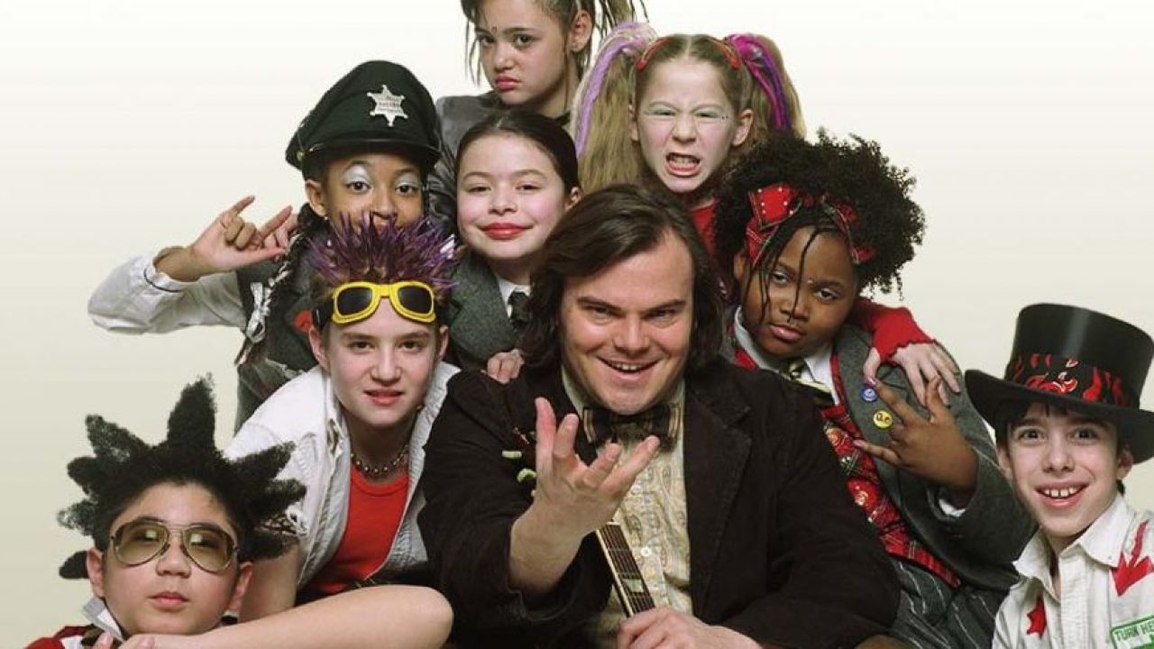 Imagem mostra Jack Black ao centro, ao lado de oito crianças, o elenco do filme 'Escola de Rock'