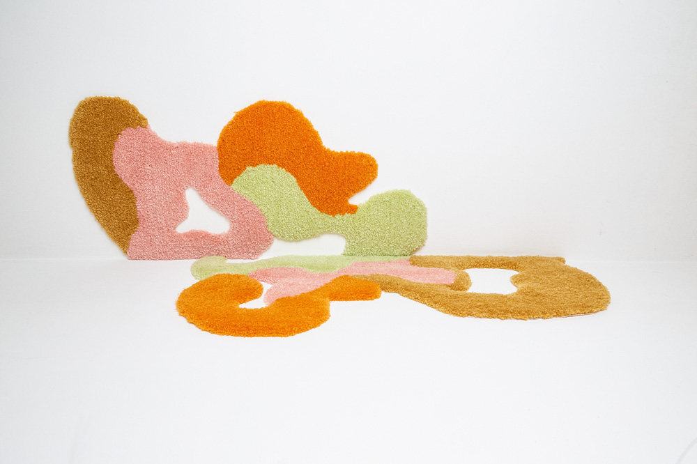 Uma peça de tapeçaria abstrata com formas arredondadas em laranja, marrom, rosa e verde