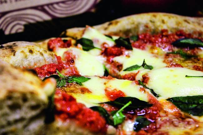 Pizza margherita aproximada: molho de tomate, muçarela e manjericão.