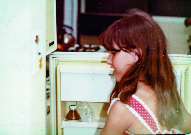 Paola Carosella Menina abrindo porta da geladeira.