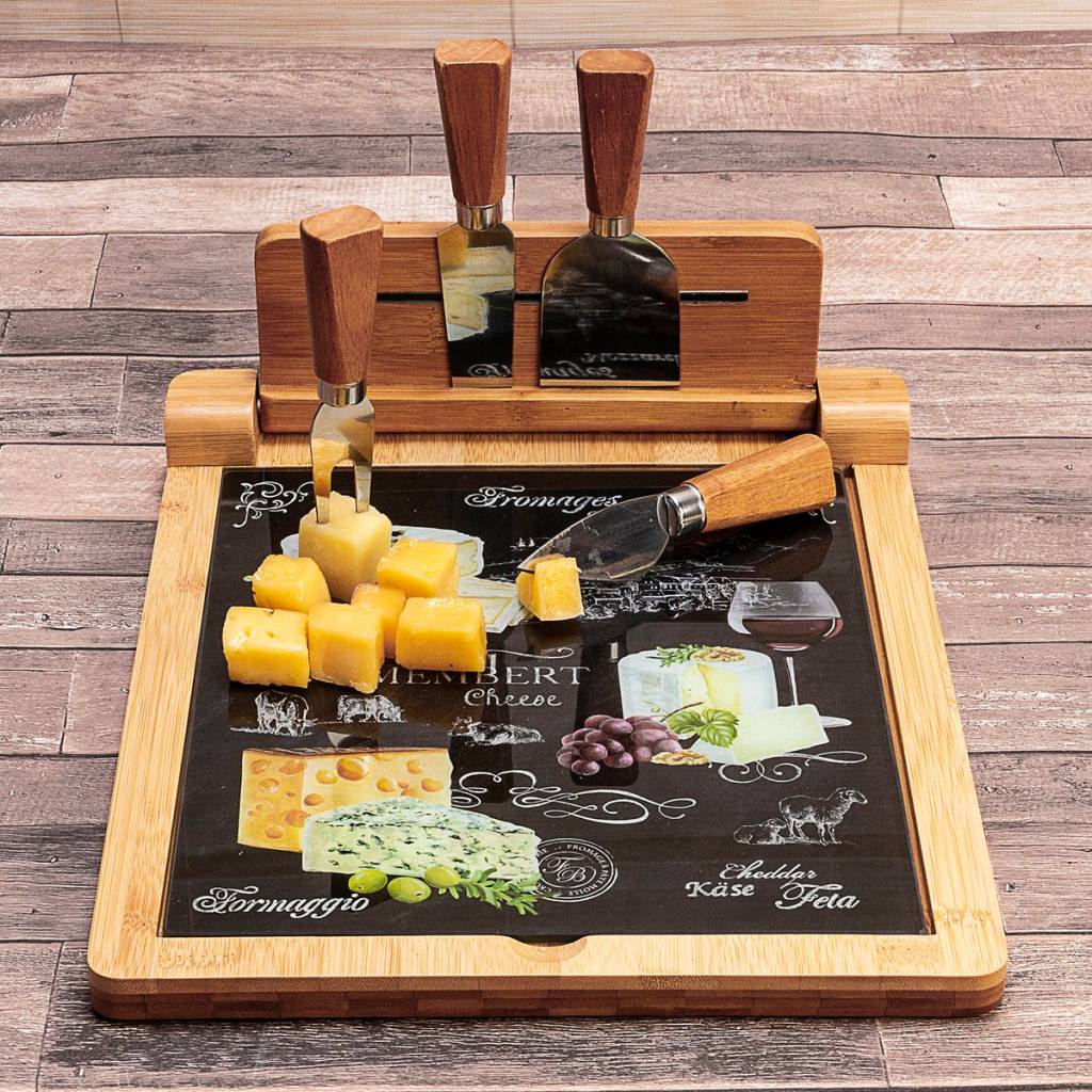 Em fundo de madeira, uma tábua de queijos tem queijos 1 faca, 1 cutelo, 1 garfo e uma espátula em cima