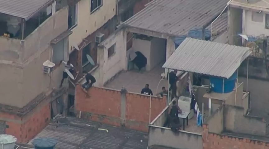 Imagem aérea mostra homens pulando entre casas durante operação na Zona Norte do Rio
