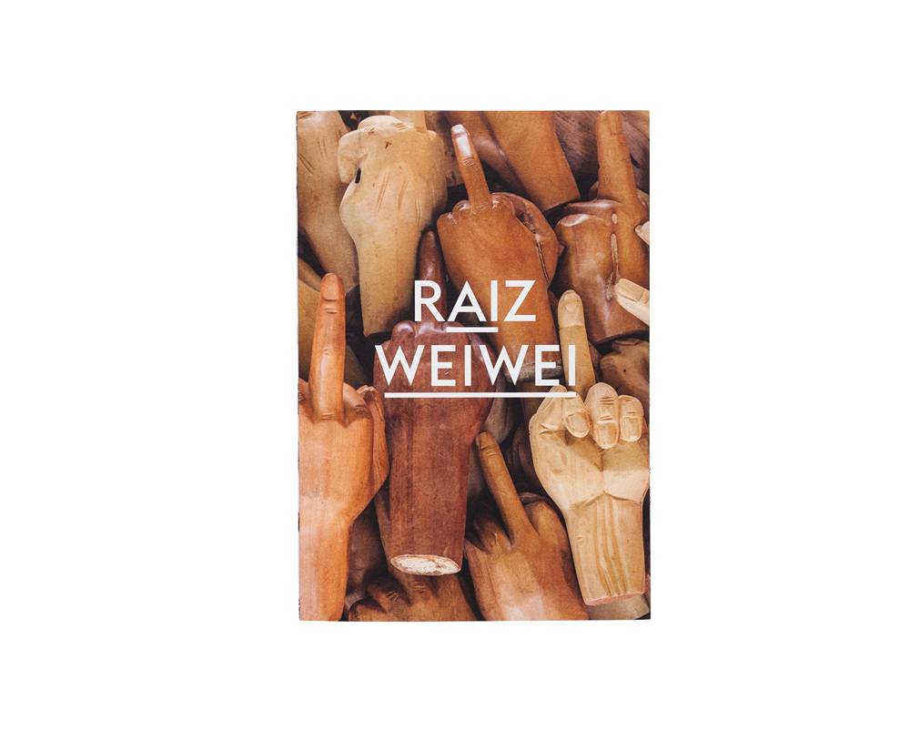 Catálogo da mostra do artista chinês Ai Weiwei. Tem várias mãos em madeira mostrando o dedo do meio