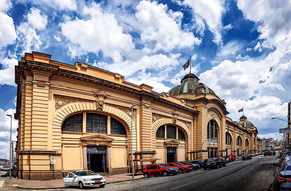 Foto do Mercado Municipal da cidade de São Paulo. Há nuvens no céu