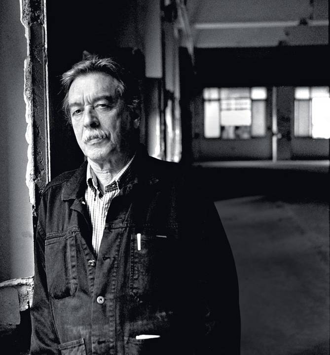 paulo mendes da rocha encostado em uma parede enquanto olha para a foto com expressão séria