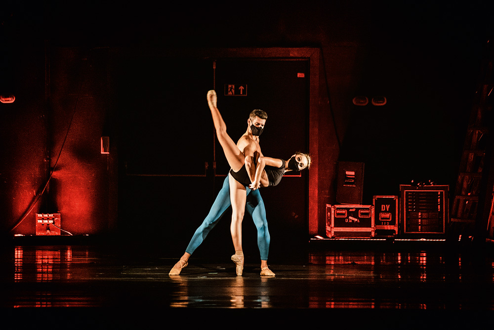 Em um palco, um homem e uma mulher dançam com roupas de balé
