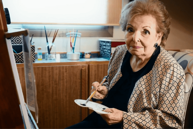 A imagem mostra Cordélia, mãe de Faustão, pintando um quadro