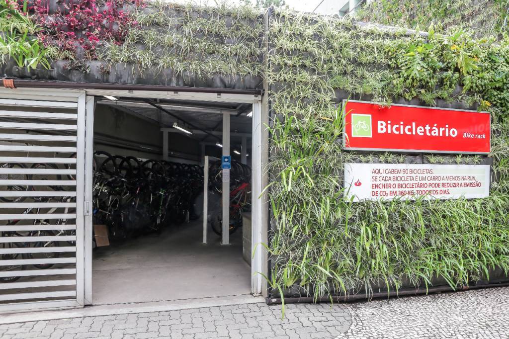 bicicletário inaugurado na estação vila olímpia da cptm, com placa identificando na direita, entrada à esquerda e plantas na fachada toda