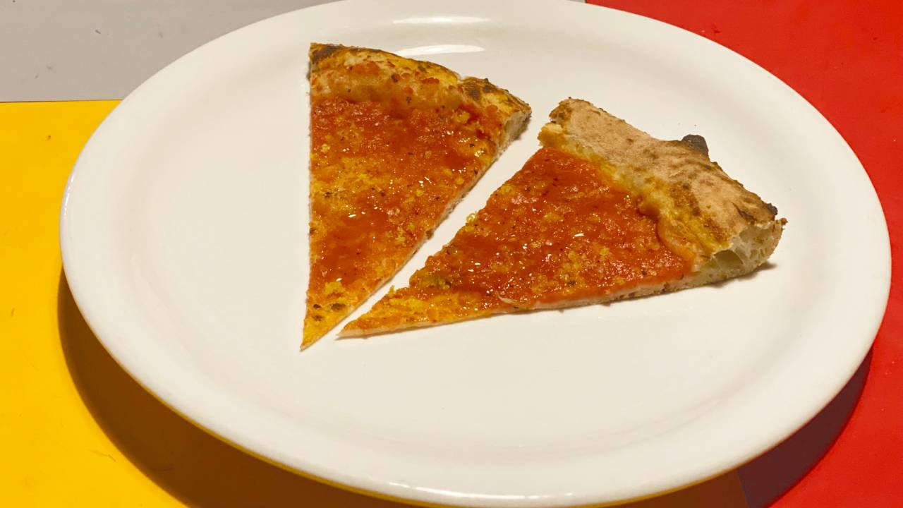 Imagem de duas fatias de pizza sobre prato branco.