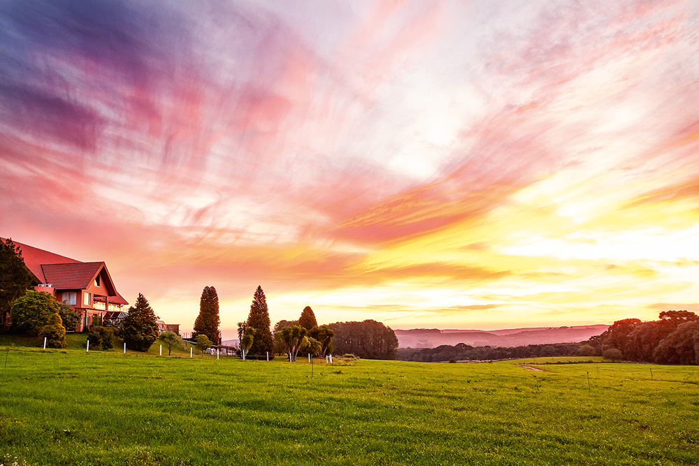 campina ao pôr do sol, com tons roxos e rosas no céu