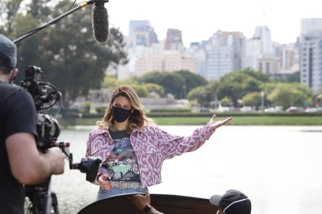 Didi Wagner fala à câmera em frente a um lago do Parque Ibirapuera.