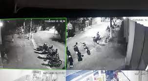Imagem de câmera de segurança em preto e branco registra acidente com BMW que atropelou motos e motociclistas.
