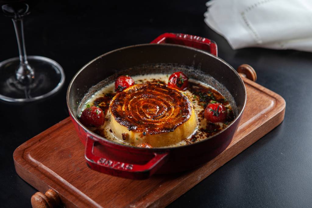 Rotolone à bolonhesa – Piccini Cucina Rotolone em panelinha de ferro, sobre tábua de madeira.