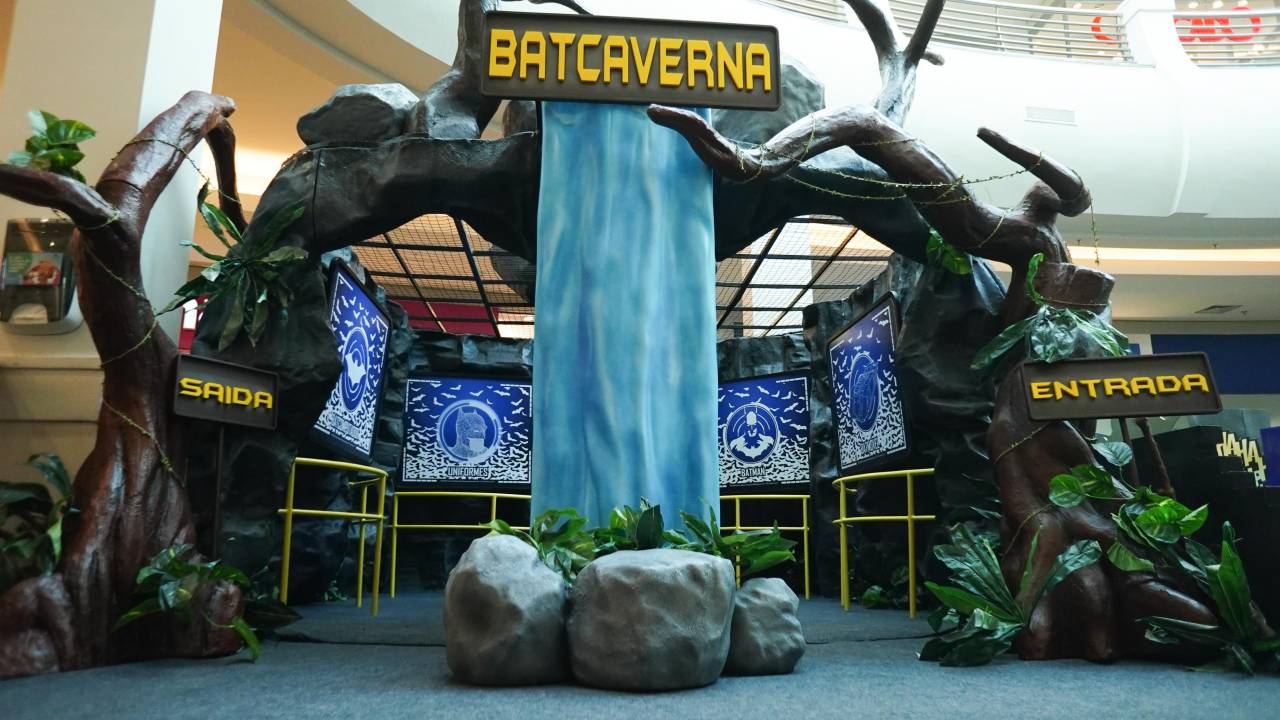 Há o cenário de uma caverna, telas e displays e o escrito "BatCaverna"
