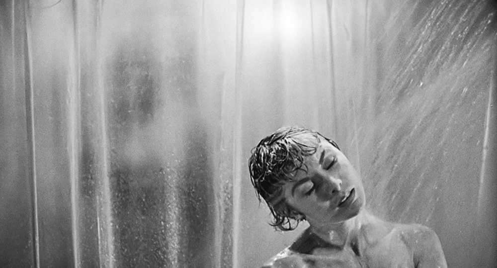 La foto mostra Janet Light sotto la doccia, dietro il suo telo trasparente, in una scena classica del film Psycho.