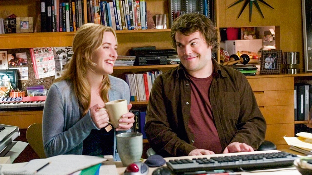 A imagem do filme mostra Jack olhando feliz com as sobrancelhas levantadas para Kate enquanto ela ri com uma xícara na mão.