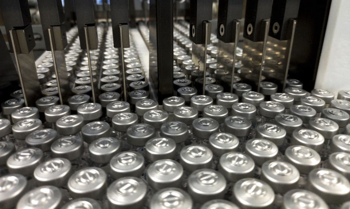 Imagem mostra esteira com centenas de frascos de vacina