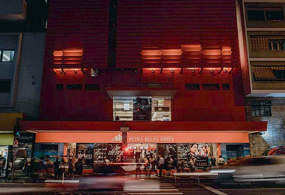 A imagem mostra a fachada do Cine Belas Artes, durante a noite, iluminado