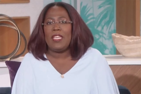 Imagem mostra Sheryl Underwood usando óculos e camisa em estúdio de TV