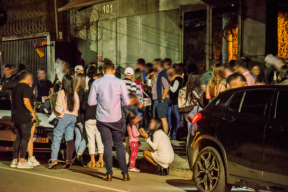 muitas pessoas bebendo e conversando em aglomeração de rua durante a pandemia no itaim bibi