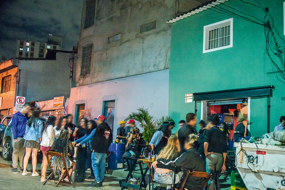 muitas pessoas bebendo e conversando em aglomeração de rua durante a pandemia na rua édson dias