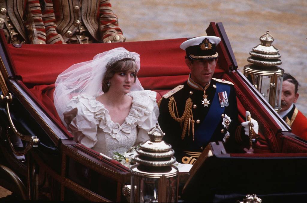 príncipe charles e princesa diana em carro aberto após cerimônia de casamento. charles olha para frente enquanto diana tem olhar de desdém para o céu