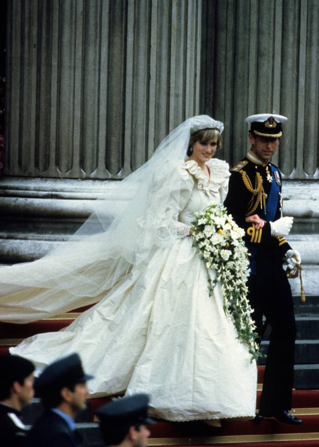 close do príncipe charles e da princesa diana descendo as escadas da igreja após sua cerimônia de casamento. no primeiro plano, guardas enfileirados pela escada desfocados