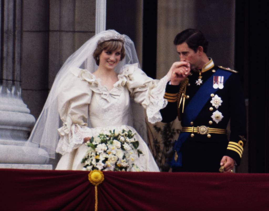Príncipe Charles beijando a mão de Princesa Diana na varanda do Palácio de Buckingham em seu dia do casamento, em 29 de julho de 1981, após a cerimônia