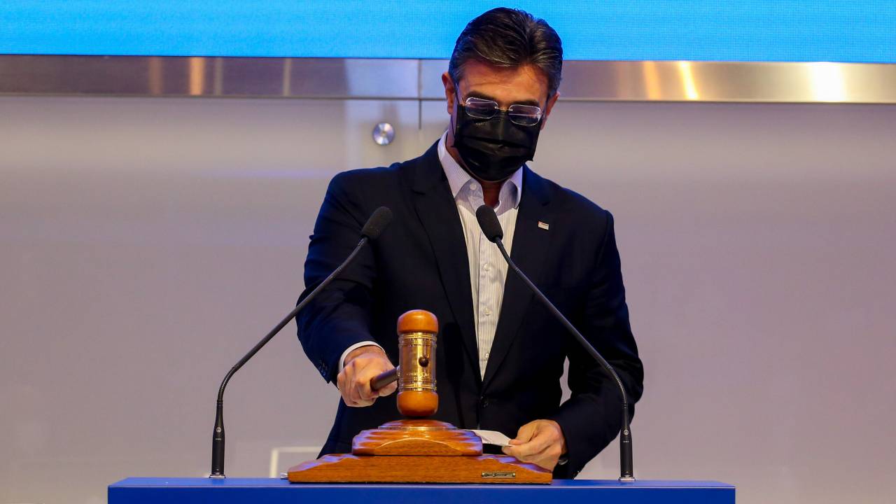 Imagem mostra Rodrigo Garcia, usando máscara, batendo martelo em placa de madeira após fim de leilão na sede da B3, em São Paulo. Ele usa terno